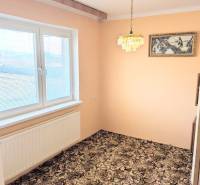 Rodinný dom s veľkou terasou a garážou v  Lastovciach za  73 500 € - V Rodinnom dome je izba s kobercovou podlahou, závesným lustrom a maľbou.