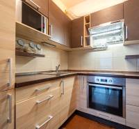 SVETLÝ ZARIADENÝ 2-IZBOVÝ BYT S BALKÓNOM - LA VITA - Kuchyňa v 2-izbovom byte s podlahou s dreveným dekorom a vstavanými spotrebičmi.