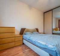 SVETLÝ ZARIADENÝ 2-IZBOVÝ BYT S BALKÓNOM - LA VITA  - Spálňa v 2-izbovom byte so zrkadlovou skriňou a posteľou, podlaha s dreveným dekorom.