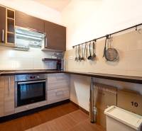 SVETLÝ ZARIADENÝ 2-IZBOVÝ BYT S BALKÓNOM - LA VITA  - Kuchyňa v 2-izbovom byte s podlahou s dreveným dekorom a praktickými úložnými priestormi.