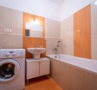 SVETLÝ ZARIADENÝ 2-IZBOVÝ BYT S BALKÓNOM - LA VITA  - Kúpeľňa v 2-izbovom byte s vaňou, umývadlom a práčkou, svetlé obloženie.