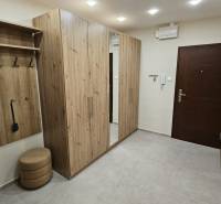 Prenájom 2 izbový byt v Topoľčanoch, sídlisko JUH - Chodba v 2-izbovom byte s nábytkom s dreveným dekorom a vstavaným zrkadlom.