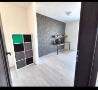 3-izb. byt v obci Blatná na Ostrove, balkón, lodžia, novostavba - Izba v 3-izbovom byte s podlahou s dreveným dekorom a dekoratívnou stenou.