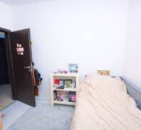 RADO I 4-IZBOVY murovaný ROD.DOM I RAJKA - Izba v rodinnom dome s posteľou, poličkou a otvorenými dverami.