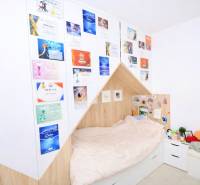 RADO I 4-IZBOVY murovaný ROD.DOM I RAJKA - Spálňa v rodinnom dome s posteľou, diplomami na stene a bielym nábytkom.