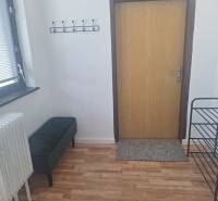 Ubytovanie pre zamestnancov, 64 m2, Tulská ul., Zvolen - Západ - V Budove s podlahou s dreveným dekorom je lavička, radiátor a vešiak na stene.