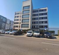 Ubytovanie pre zamestnancov, 64 m2, Tulská ul., Zvolen - Západ - Budova na Tulskiej ulici vo Zvolene, pred ktorou parkujú autá.