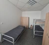 Ubytovanie pre zamestnancov, 64 m2, Tulská ul., Zvolen - Západ - Interiér budovy s posteľami a skriňami, podlaha s dreveným dekorom.