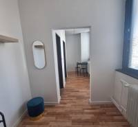 Ubytovanie pre zamestnancov, 64 m2, Tulská ul., Zvolen - Západ - Interiér budovy s podlahou s dreveným dekorom, stoličky, zrkadlo, biely strop.