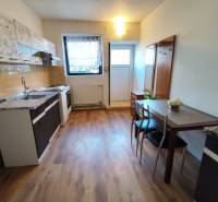 Na prenájom 1-izbový byt - Nové Zámky - Kuchyňa v 1-izbovom byte s podlahou s dreveným dekorom a jedálenským stolom.