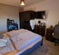 EXKLUZÍVNE-PREDAJ 3-IZBOVÝ BYT POPRAD, juh-bl.Slnečnica 80 m2  2 balk. - Spálňa v 3-izbovom byte s komfortnou posteľou, pracovným stolom a podlahou s dreveným dekorom.