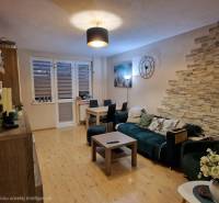 EXKLUZÍVNE-PREDAJ 3-IZBOVÝ BYT POPRAD, juh-bl.Slnečnica 80 m2  2 balk. - Obývačka v 3-izbovom byte s podlahou s dreveným dekorom a dekoratívnymi prvkami.