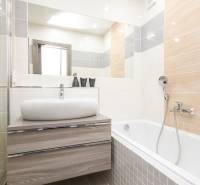 3i byt 73m2 + 6m2 balkón, Gen. Svobodu, Trenčín - Kúpeľňa v 3-izbovom byte s vaňou, umývadlom a podlahou s dreveným dekorom.