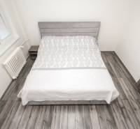 3i byt 73m2 + 6m2 balkón, Gen. Svobodu, Trenčín - Spálňa v 3-izbovom byte s posteľou a podlahou s dreveným dekorom.