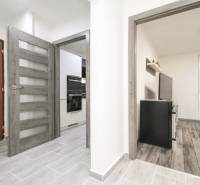 3i byt 73m2 + 6m2 balkón, Gen. Svobodu, Trenčín - Chodba v 3-izbovom byte s podlahou s dreveným dekorom a vstupom do kuchyne.