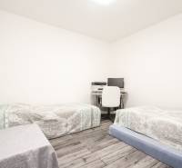 3i byt 73m2 + 6m2 balkón, Gen. Svobodu, Trenčín - Izba v 3-izbovom byte, dve postele, pracovný stôl, podlaha s dreveným dekorom.