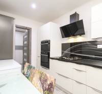 3i byt 73m2 + 6m2 balkón, Gen. Svobodu, Trenčín - Kuchyňa v 3-izbovom byte s čiernymi spotrebičmi a skleneným stolom.