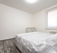 3i byt 73m2 + 6m2 balkón, Gen. Svobodu, Trenčín - Spálňa v 3-izbovom byte s podlahou s dreveným dekorom a veľkými oknami.