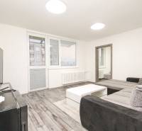 3i byt 73m2 + 6m2 balkón, Gen. Svobodu, Trenčín - Obývacia izba s podlahou s dreveným dekorom, sedačkou a stolíkom v 3-izbovom byte.