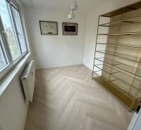 Na predaj moderný 2-izbový byt po kompletnej rekonštrukcii – Piešťany - Izba v 2-izbovom byte s poličkou, podlahou s dreveným dekorom a oknom.