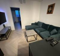 Na predaj moderný 2-izbový byt po kompletnej rekonštrukcii – Piešťany - Obývacia izba v 2-izbovom byte s podlahou s dreveným dekorom a pohodlnou sedačkou.