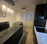 Na predaj moderný 2-izbový byt po kompletnej rekonštrukcii – Piešťany - Kuchyňa v 2-izbovom byte so sklenenými svietidlami a podlahou s dreveným dekorom.