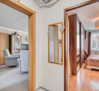 REZERVOVANÉ 4-izbový byt v Trnave na Veternej ulici - Interiér 4-izbového bytu s podlahou s dreveným dekorom, nábytkom a zrkadlom.