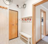 REZERVOVANÉ 4-izbový byt v Trnave na Veternej ulici - Vstupná chodba v 4-izbovom byte, biele steny, vešiaky a lavica.