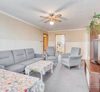 REZERVOVANÉ 4-izbový byt v Trnave na Veternej ulici - Obývacia izba v 4-izbovom byte so šedou sedačkou, stolíkom a stropným ventilátorom.