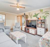 REZERVOVANÉ 4-izbový byt v Trnave na Veternej ulici - Obývačka v 4-izbovom byte s pohodlným sedením, izbovými rastlinami a kobercom.