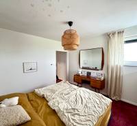 Nová Dedinka,projekt “Lastovičky”,na predaj moderný radový rodinný dom - Spálňa v rodinnom dome s posteľou, zrkadlom a červeným kobercom na podlahe.