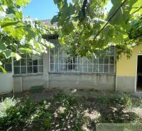 Rodinný dom v pôvodnom stave na 7 árovom pozemku v Tvrdošovciach - Rodinný dom v Tvrdošovciach s verandou obklopený zeleňou, záhrada s viničom.