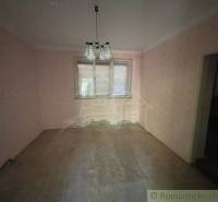 Rodinný dom v pôvodnom stave na 7 árovom pozemku v Tvrdošovciach - Miestnosť v rodinnom dome s ružovými stenami a podlahou s dreveným dekorom.