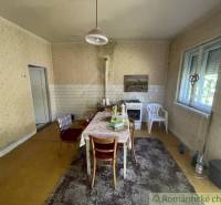 Rodinný dom v pôvodnom stave na 7 árovom pozemku v Tvrdošovciach - Jedáleň v rodinnom dome s kuchynským stolom a kobercom, klasická atmosféra.