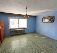 5 izbový dom Mankovce - Interiér v rodinnom dome s modrou stenou, kobercom a závesným svietidlom.