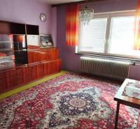 5 izbový dom Mankovce - Fialové steny a luxusný luster zdobia miestnosť v rodinnom dome s výrazným kobercom.