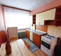 5 izbový dom Mankovce - Kuchyňa v rodinnom dome s dreveným dekorom podlahy, plynový sporák, jedálenský stôl.