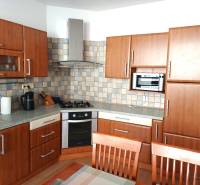 Zariadený 3 izbový byt s lodžiou, Beniakova ulica, BA IV. Karlova Ves - Kuchyňa v 3-izbovom byte s podlahou s dreveným dekorom a kuchynskou linkou.