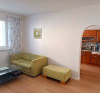 Zariadený 3 izbový byt s lodžiou, Beniakova ulica, BA IV. Karlova Ves - Obývacia izba v 3-izbovom byte s pohovkou, stolíkom a kuchynským kútom.