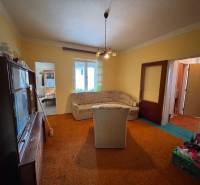 NA PREDAJ!!! Rodinný dom s veľkým pozemkom v obci Vék pri Hurbanove - Obývacia izba rodinného domu so starším nábytkom, pohovkou a kobercom.