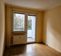 PRENÁJOM 3 izbový zariadený byt,  Nitra - Diely - Prázdna izba v 3-izbovom byte s podlahou s dreveným dekorom a presklenými dverami na balkón.