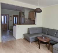 PRENÁJOM 3 izbový zariadený byt,  Nitra - Diely - Obývacia izba s rohovou sedačkou a podlahou s dreveným dekorom v 3-izbovom byte.