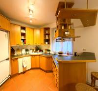 3 izbový byt s balkónom v obľúbenej lokalite Neusiedl am See - Kuchyňa v 3-izbovom byte s drevenými skrinkami a barovým pultom.