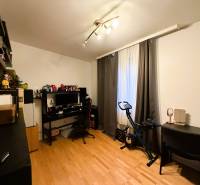 3 izbový byt s balkónom v obľúbenej lokalite Neusiedl am See - Izba s podlahou s dreveným dekorom, písací stôl, počítač, stacionárny bicykel, police.