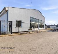 Na prenájom obchodný priestor s kanceláriou, Štúrovo - Obchodné priestory v Štúrove so sivou fasádou, parkovaním a prístreškom.