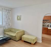 – PRENAJOM – 3 IZBOVÝ BYT – BENIAKOVA – KARLOVA VES  - Obývačka v 3-izbovom byte s pohovkou, stolíkom a oblúkom do kuchyne.