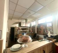 PRENÁJOM - Bistro/ Gastro prevádzka - Košice - Juh - Interiér gastro priestoru s podlahou s dreveným dekorom, pultom, zákuskom a taniermi.