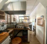 PRENÁJOM - Bistro/ Gastro prevádzka - Košice - Juh - Kuchynský priestor s nerezovým digestorom a podlahou s dreveným dekorom v gastro priestoroch.