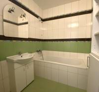 Predaj 3 - izbového bytu - Nová Baňa - Kúpeľňa v 3-izbovom byte s vaňou, umývadlom a zelenými obkladmi.