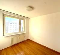 Zrekonštruovaný 3i byt na začiatku Petržalky, električka, les, výhľady - Izba v 3-izbovom byte s bielymi stenami a podlahou s dreveným dekorom.